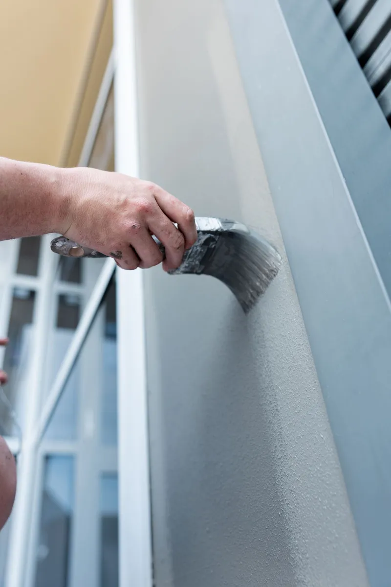 Brush working primer into a wall edge