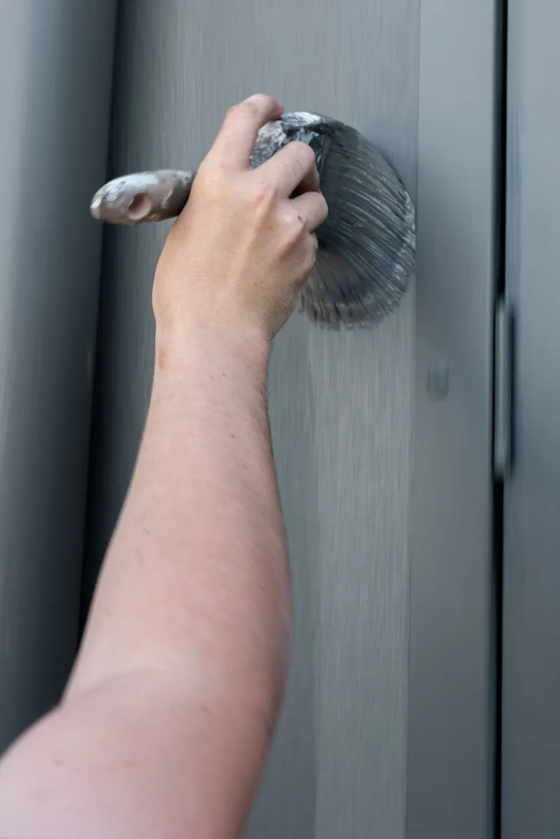 Mini roller laying a top coat onto a smooth wall