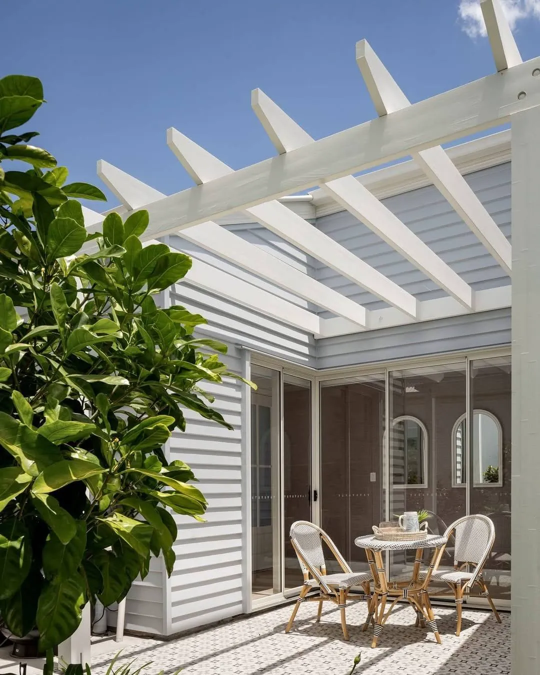 White pergola and weatherboard courtyard freshly painted